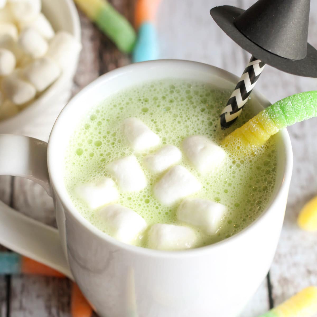 Green white chocolate cocoa topped with marshmallows in a white mug.