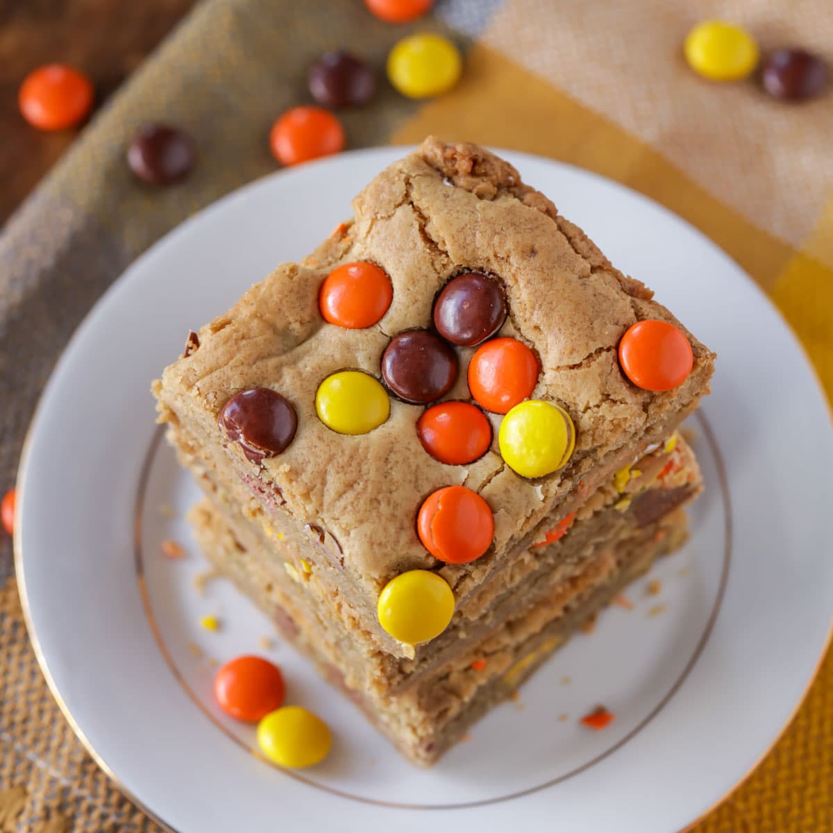 Cookie bar recipes - reeses pieces bars stacked on a white plate.