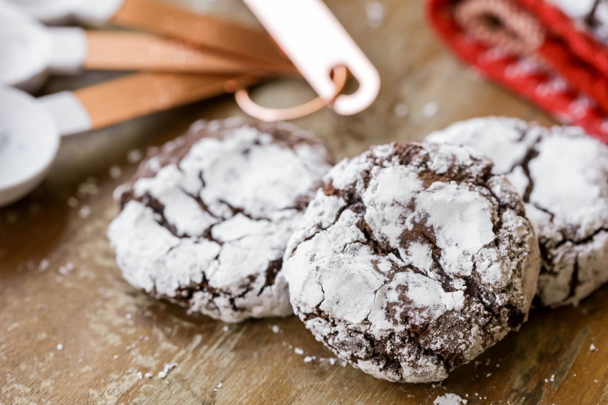 Easy cookie recipes - powder sugar covered crinkles cookies on a wooden table.