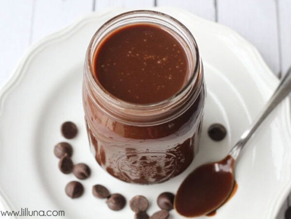 Hot fudge sauce recipe in a mason jar on a white plate.