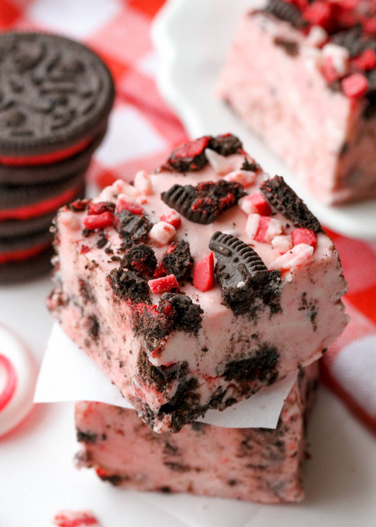 close up of peppermint oreo fudge stacked with wax paper