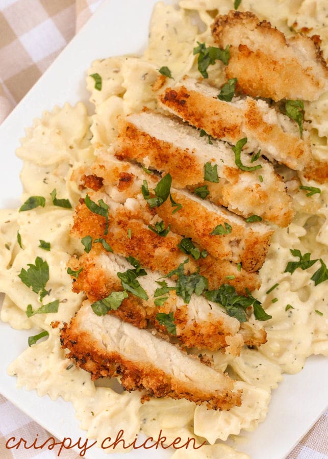 Slice crispy chicken served over a bed of creamy pasta