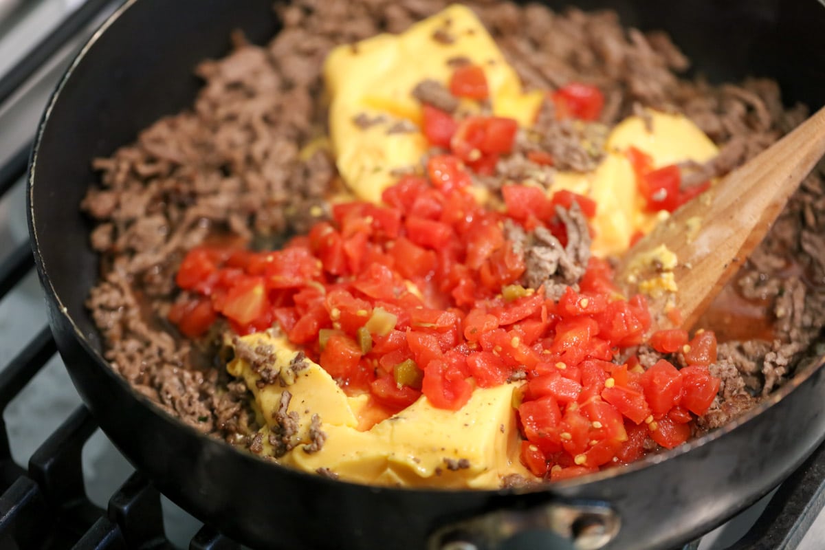 Hamburger dip ingredients cooking in a skillet.