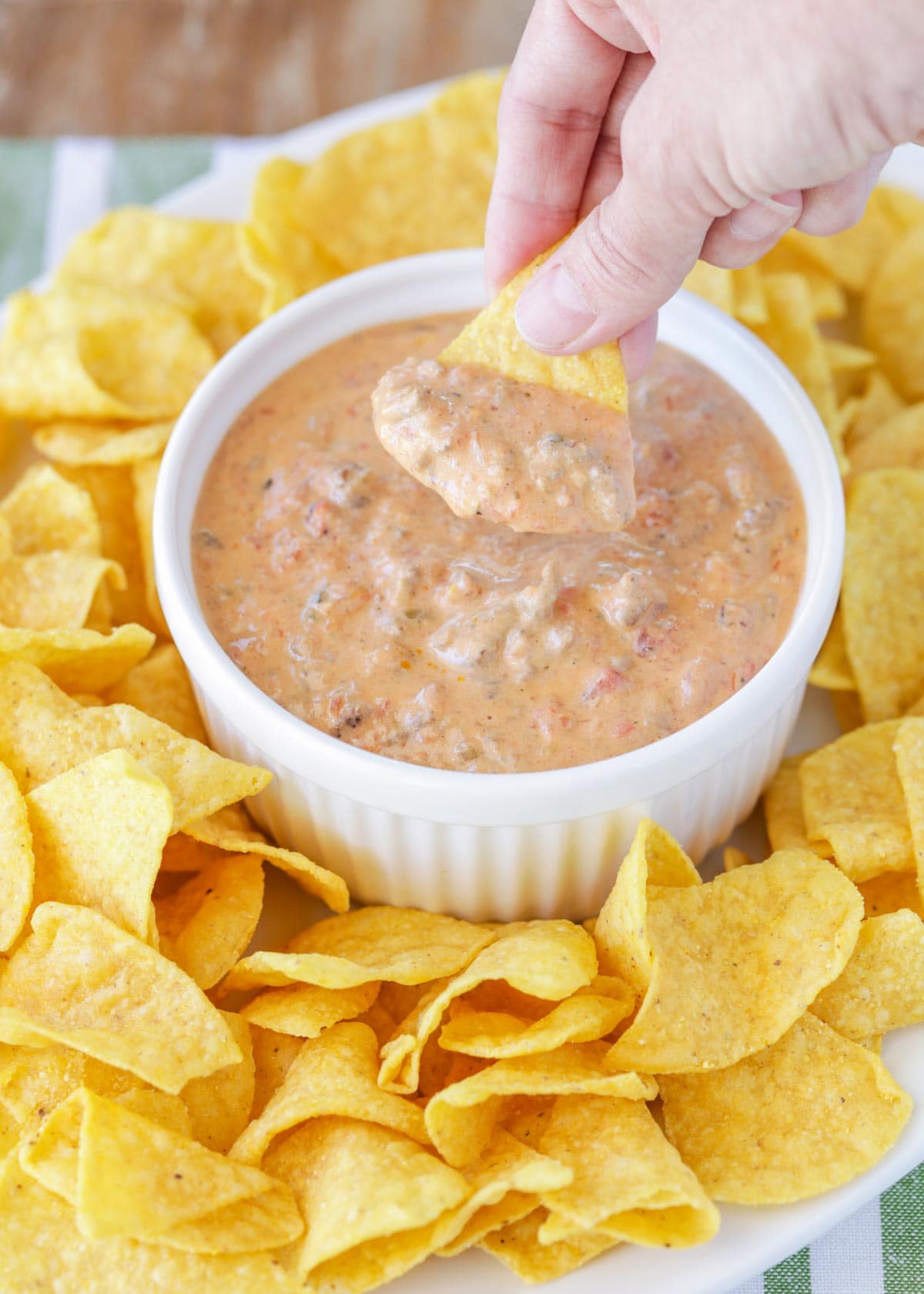 Dipping a tortilla chip into velveeta hamburger dip.