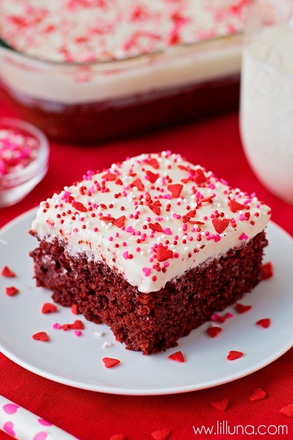Holiday cakes - square slice of red velvet poke cake topped with sprinkles.
