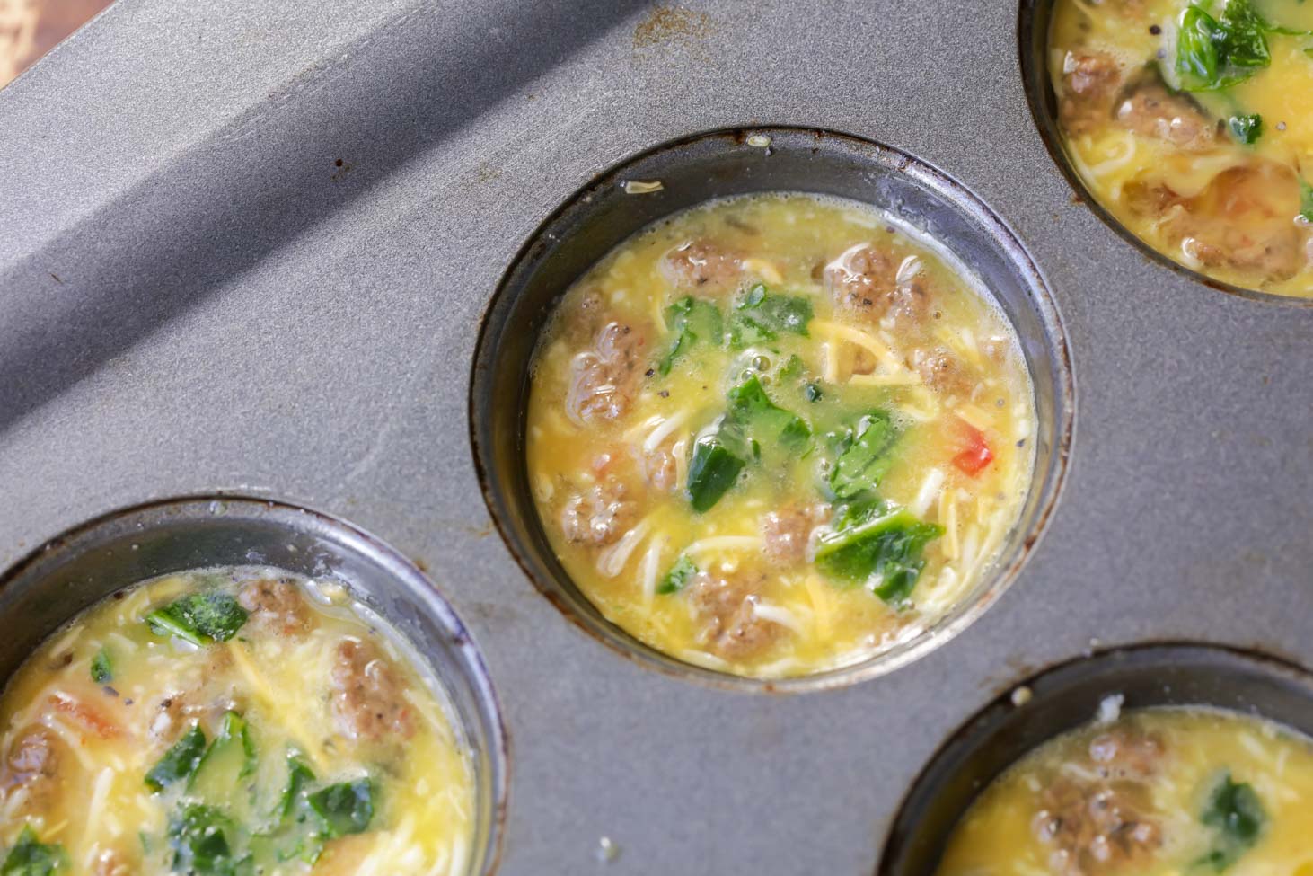 Raw egg muffins in a muffin tin