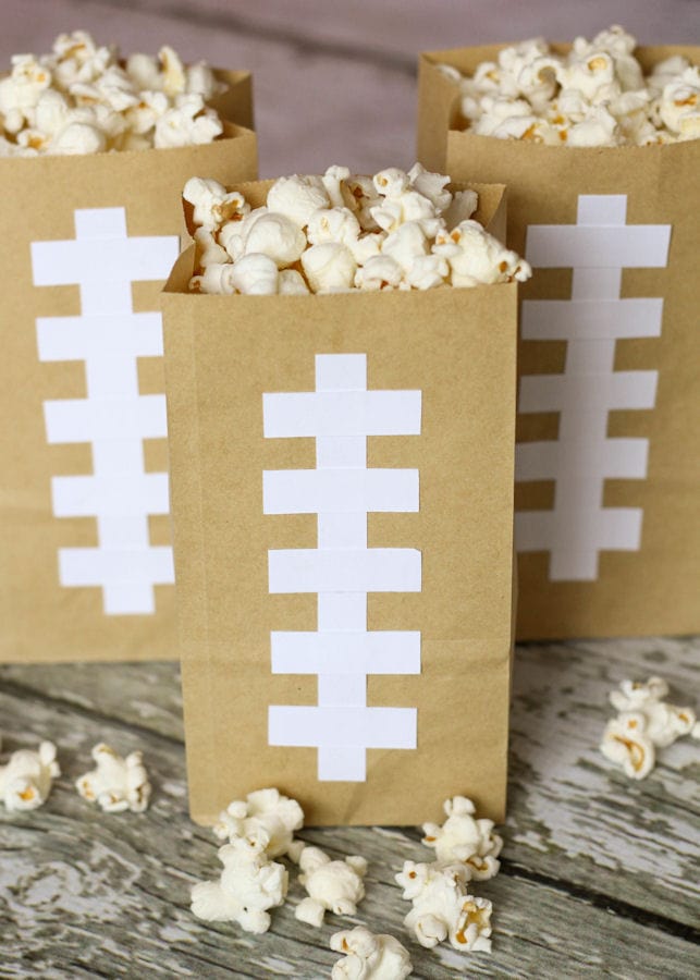 Make cute and simple Football Bags to hold your Homemade Butter Popcorn. They are easy to re-fill and can be used all Super Bowl Sunday long which limits the mess and cuts down the use of more paper goods.
