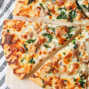 Chicken Alfredo Pizza recipe with slice cut out on cutting board.