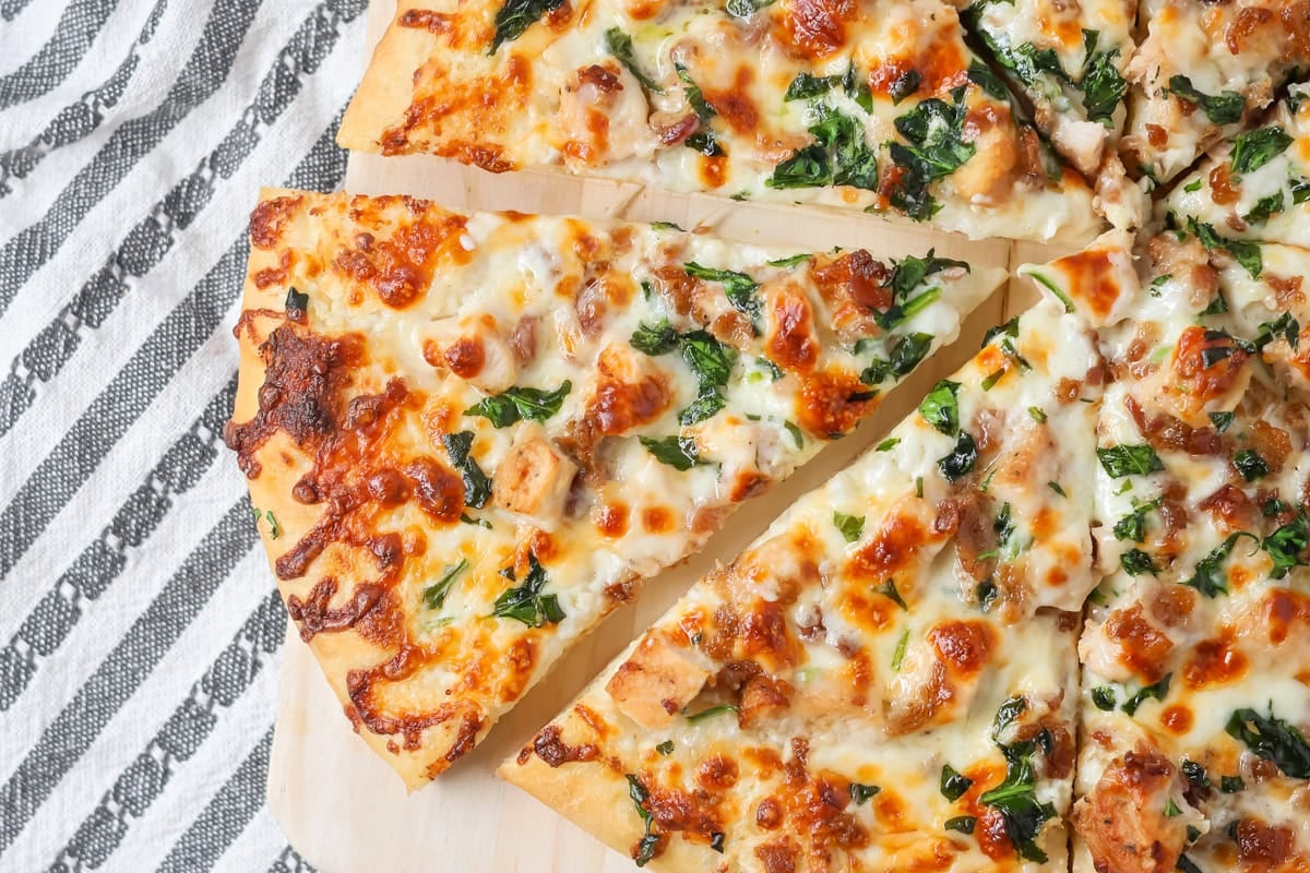 Chicken Alfredo pizza recipe with slice cut out.