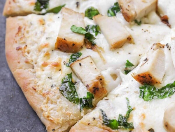 Chicken Alfredo pizza recipe on cutting board.