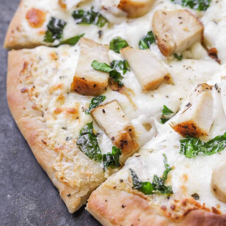 Chicken Alfredo pizza recipe on cutting board.