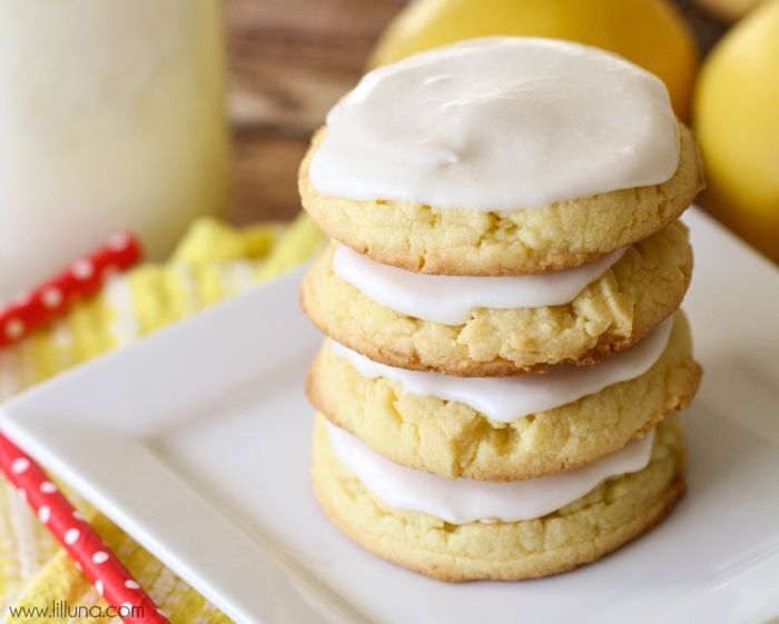 Easy cookie recipes - frosted lemon cookies stacked on a white plate.