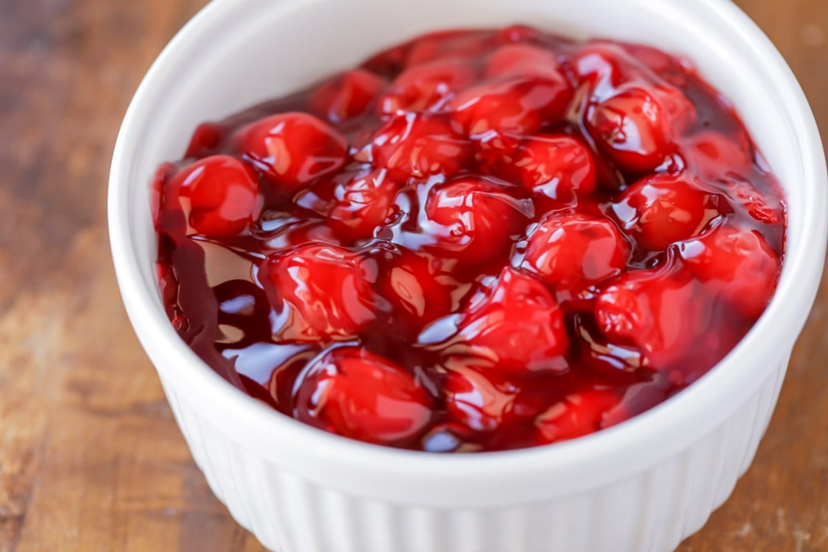 Cherry pie filling in a white bowl.