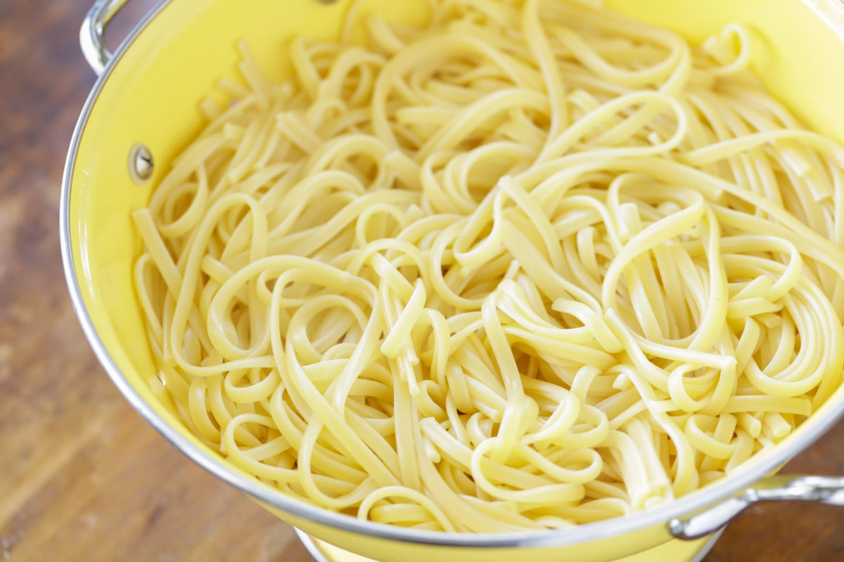 yellow colander filled with cooked pasta