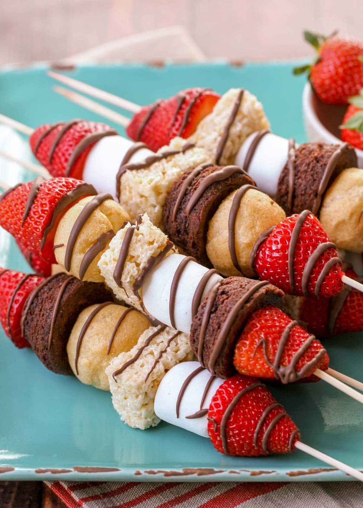 Close up of dessert kabobs on a blue plate