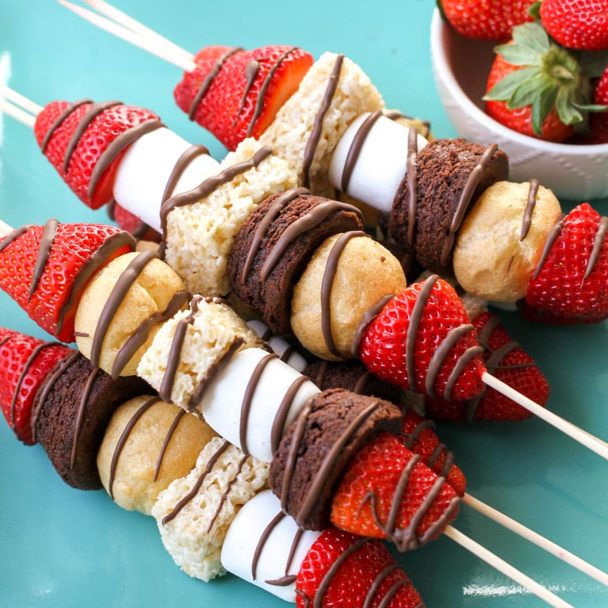 Valentines Dinner Ideas - dessert kabobs on wooden skewers drizzled with chocolate.