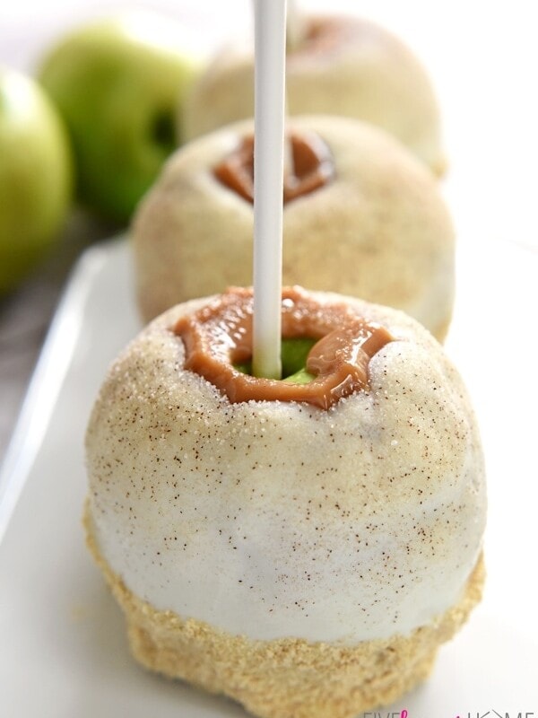 Apple Pie Caramel Apples {Disney Copycat Recipe} ~ tart Granny Smith apples are dipped in chewy caramel, coated in white chocolate, sprinkled with cinnamon sugar, and then finished off with pie crust crumbs for your favorite Disney treat easily made at home for a fraction of the price! | FiveHeartHome.com for LilLuna.com