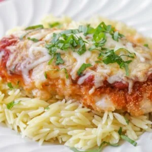 Baked chicken parmesan served on pasta.