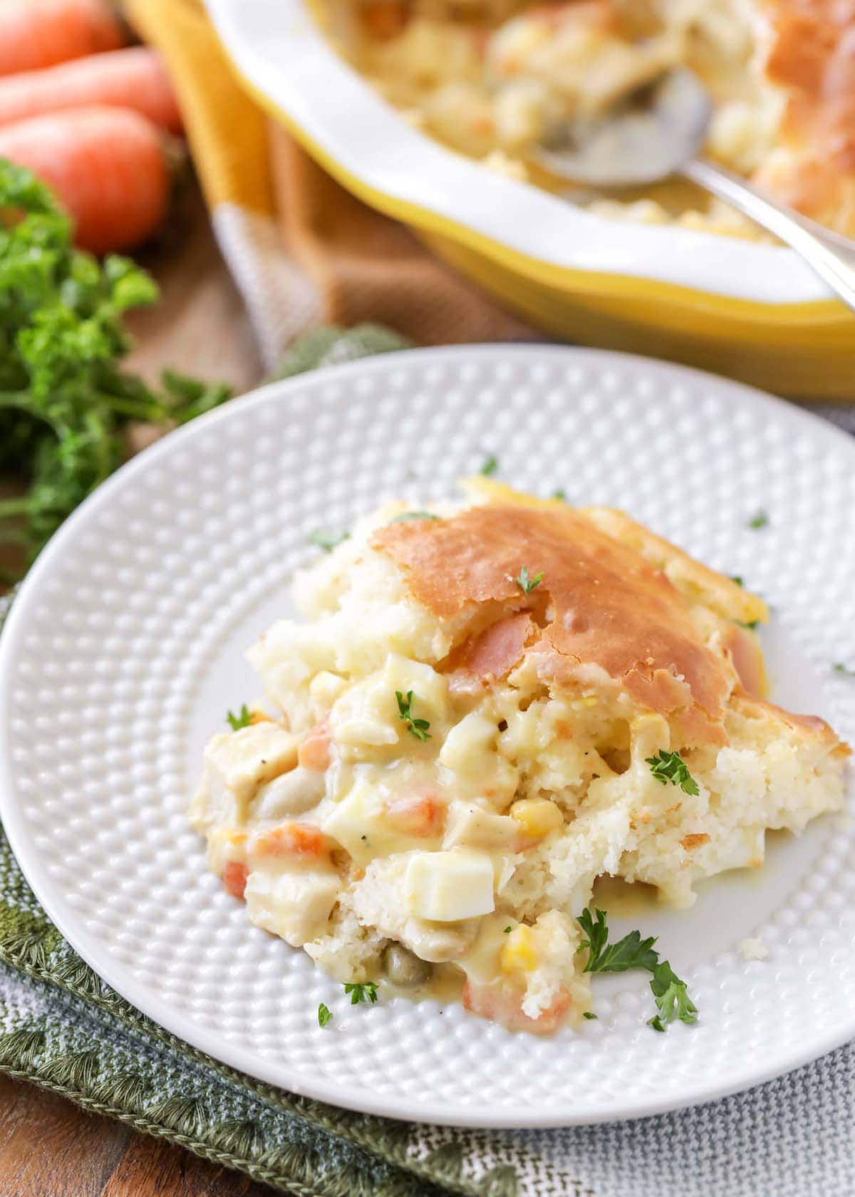 A spoonful of Bisquick chicken pot pie on a white plate.