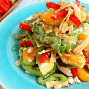 Loaded with sweet, tropical flavors, this delicious Luau Salad is BETTER than what you'll get at Cheesecake Factory! Fresh pineapple, mandarin oranges, celery, onions, wantons and a sweet pineapple balsamic dressing top this easy-to-make layered salad. Perfect for summer on the patio!