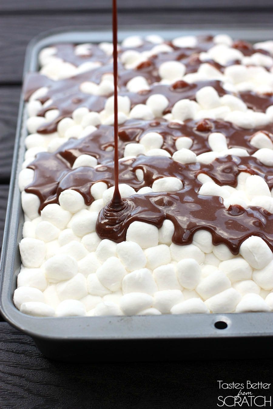 Drizzling chocolate frosting on top of Mississippi Mud Cake recipe.