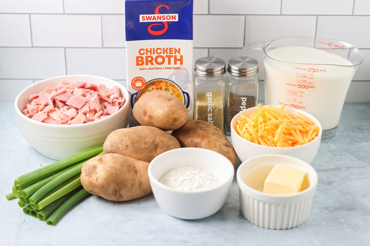Ingredients for ham and potato soup on a kitchen counter.