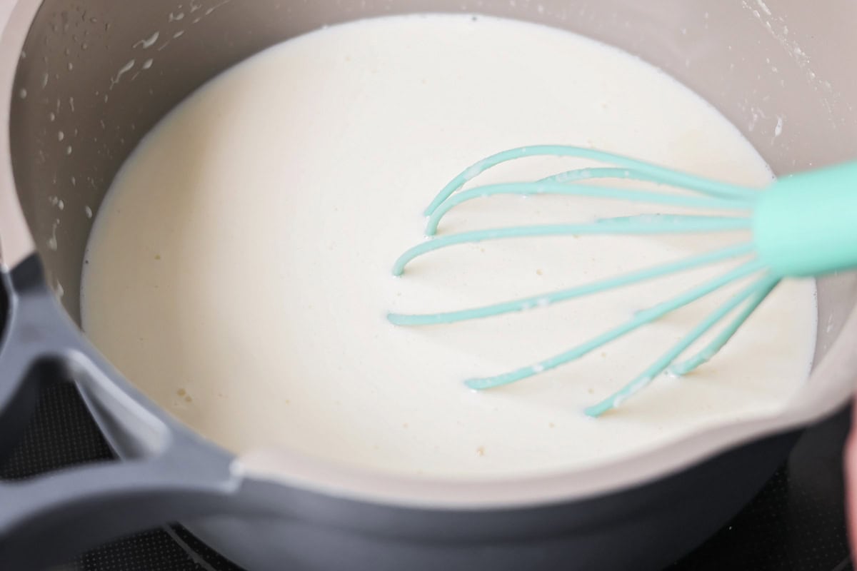 Whisking the roux into the ham and potato soup.