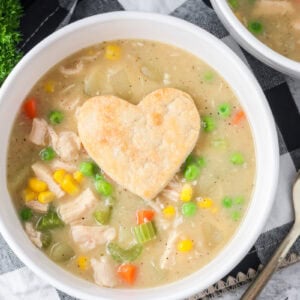 Chicken pot pie soup served in bowl with pie crust heart on top.
