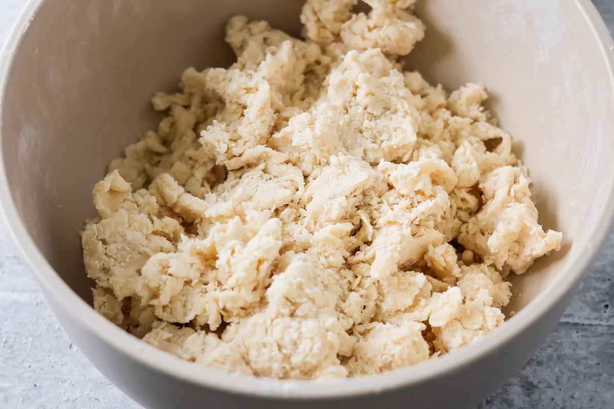 Pie crust dough being made in a bowl.