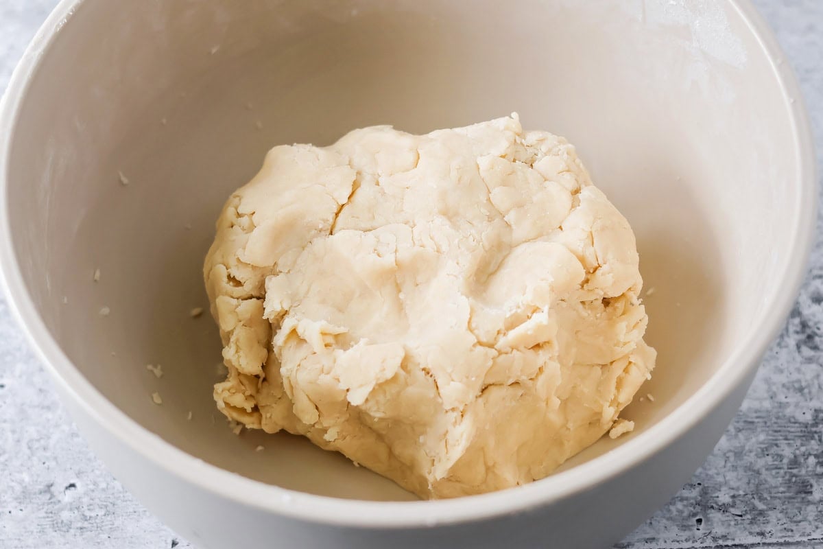 Flaky pie crust dough in mixing bowl.