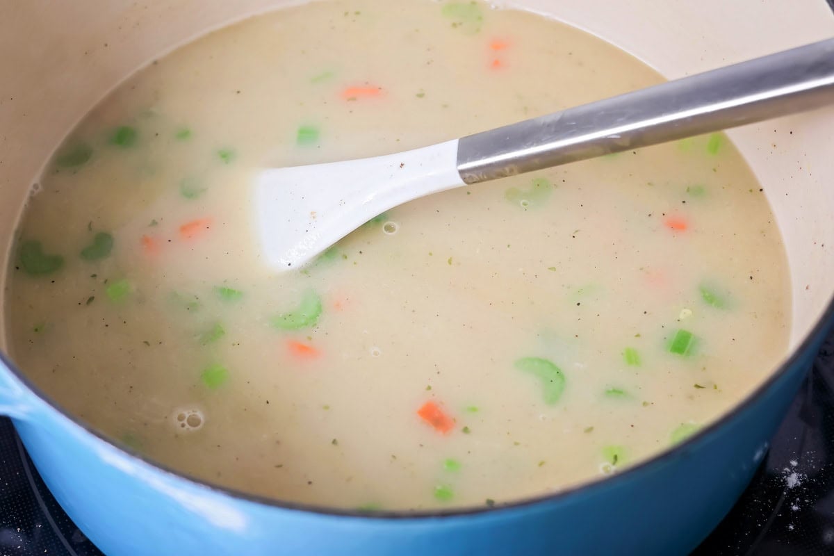 Chicken pot pie soup being made in a pot.