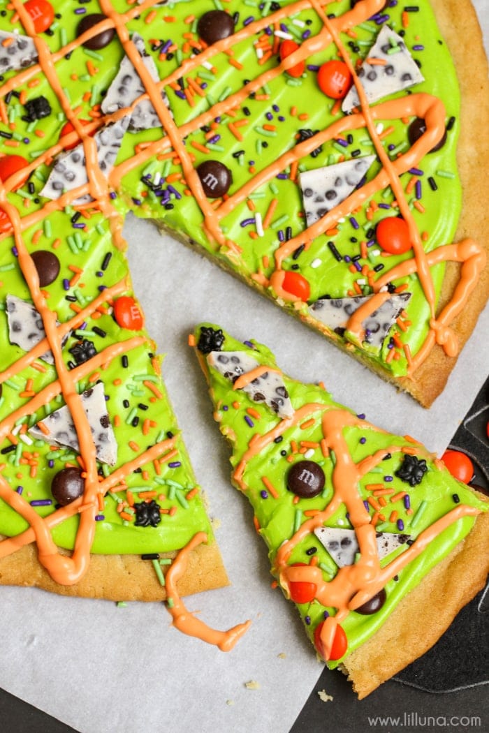 Halloween dinner ideas - green Halloween sugar cookie cake sliced and drizzled with orange frosting.