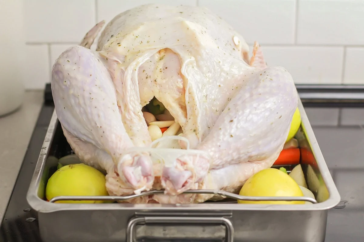 Apples added to the roasting pan with veggies and stuffed turkey.