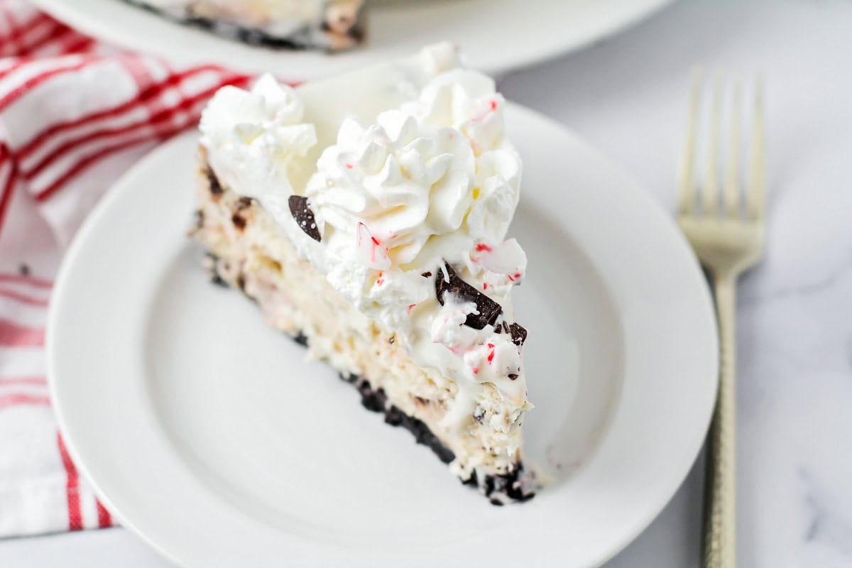 A slice of peppermint cheesecake on a white plate.