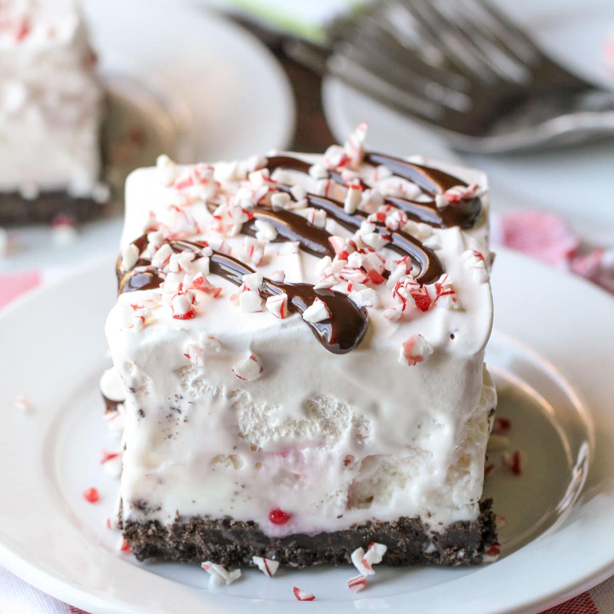 Christmas desserts - square slice of peppermint ice cream dessert drizzled with chocolate sauce.
