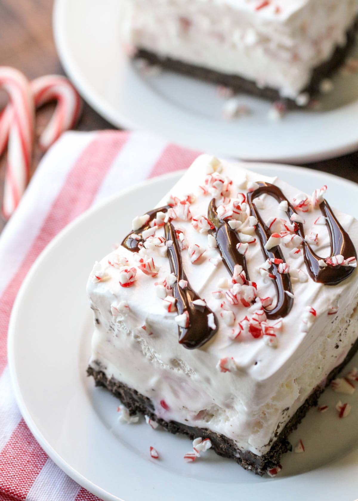 slice of peppermint ice cream dessert topped with chocolate syrup and crushed peppermint.