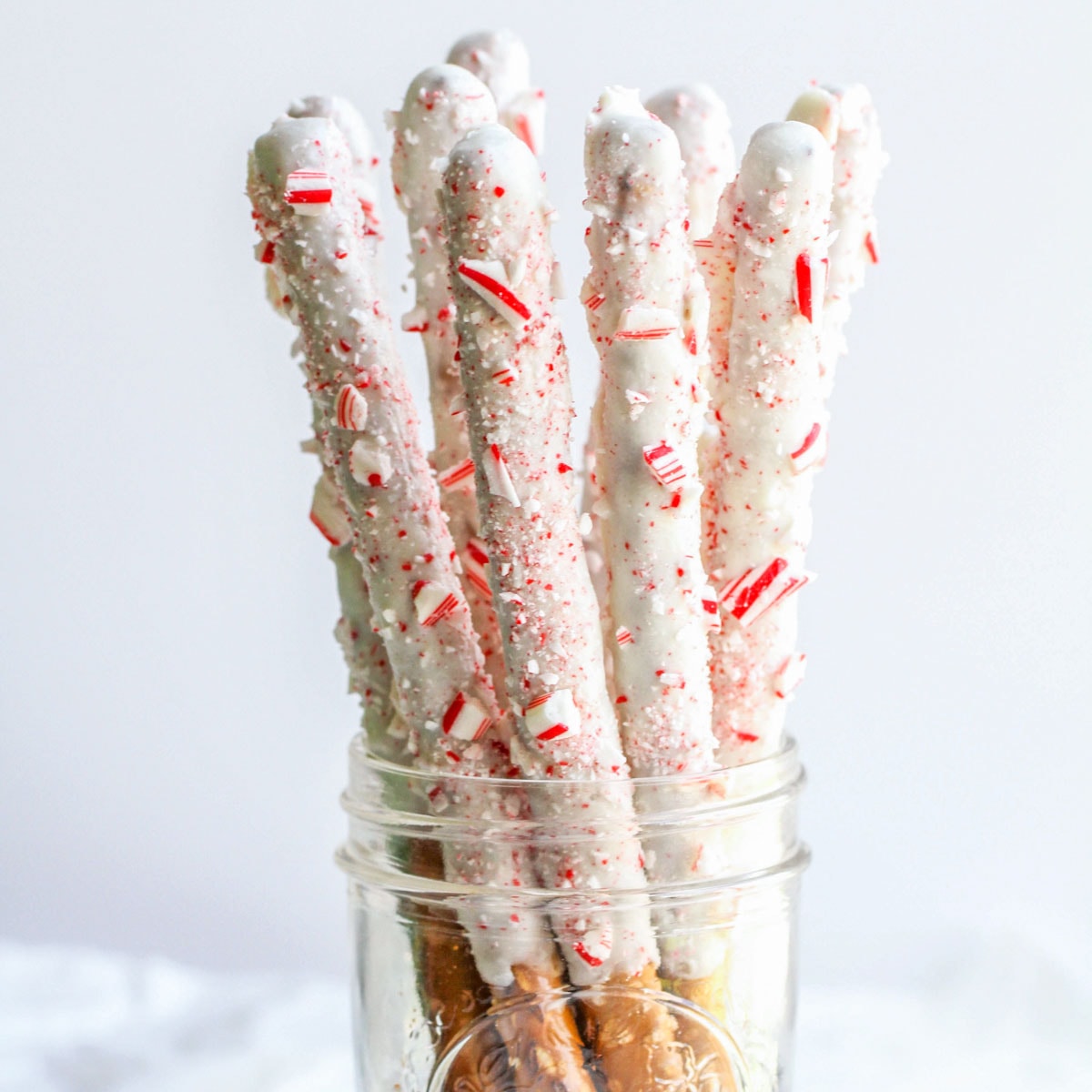 White Chocolate Peppermint Pretzels placed in a glass mason jar.