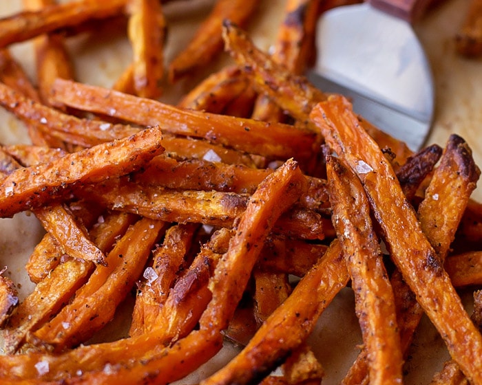 Baked Sweet Potato Fries being scooped with a spatula