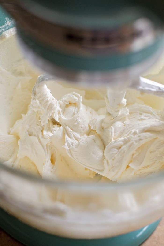 Whipped buttercream in a glass mixing bowl.