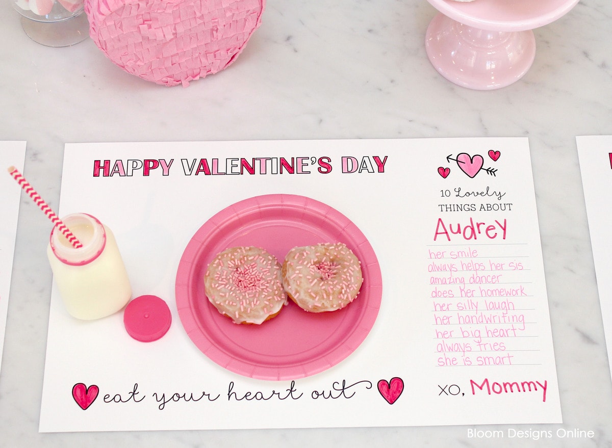 A printable valentines placemat on a countertop with a plate of donuts sitting on top of it. 