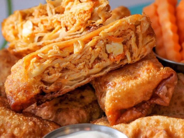 Buffalo chicken egg rolls with ranch dressing in silver cup