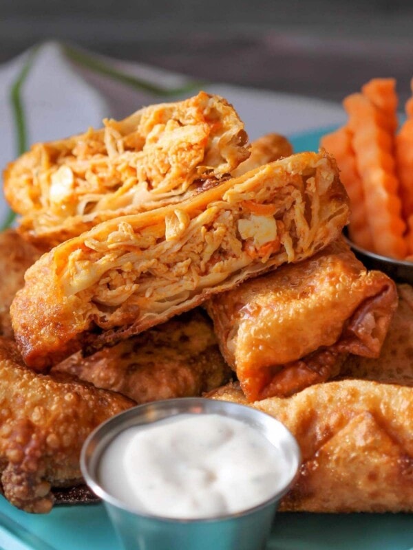 Buffalo chicken egg rolls with ranch dressing in silver cup