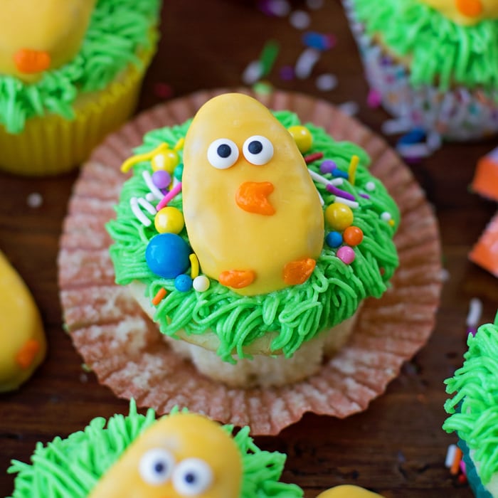 Easter Chick Cupcakes decorated with frosting, Reese's Easter Eggs, and sprinkles.