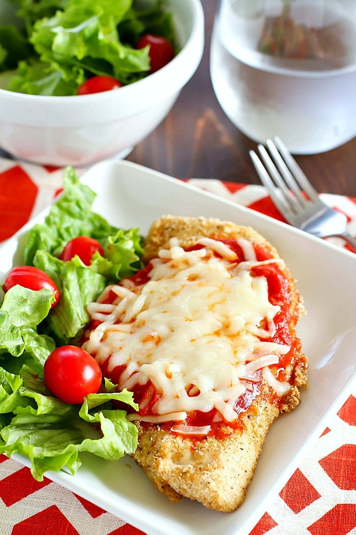 Healthy Chicken Parmesan recipe served with a side salad.