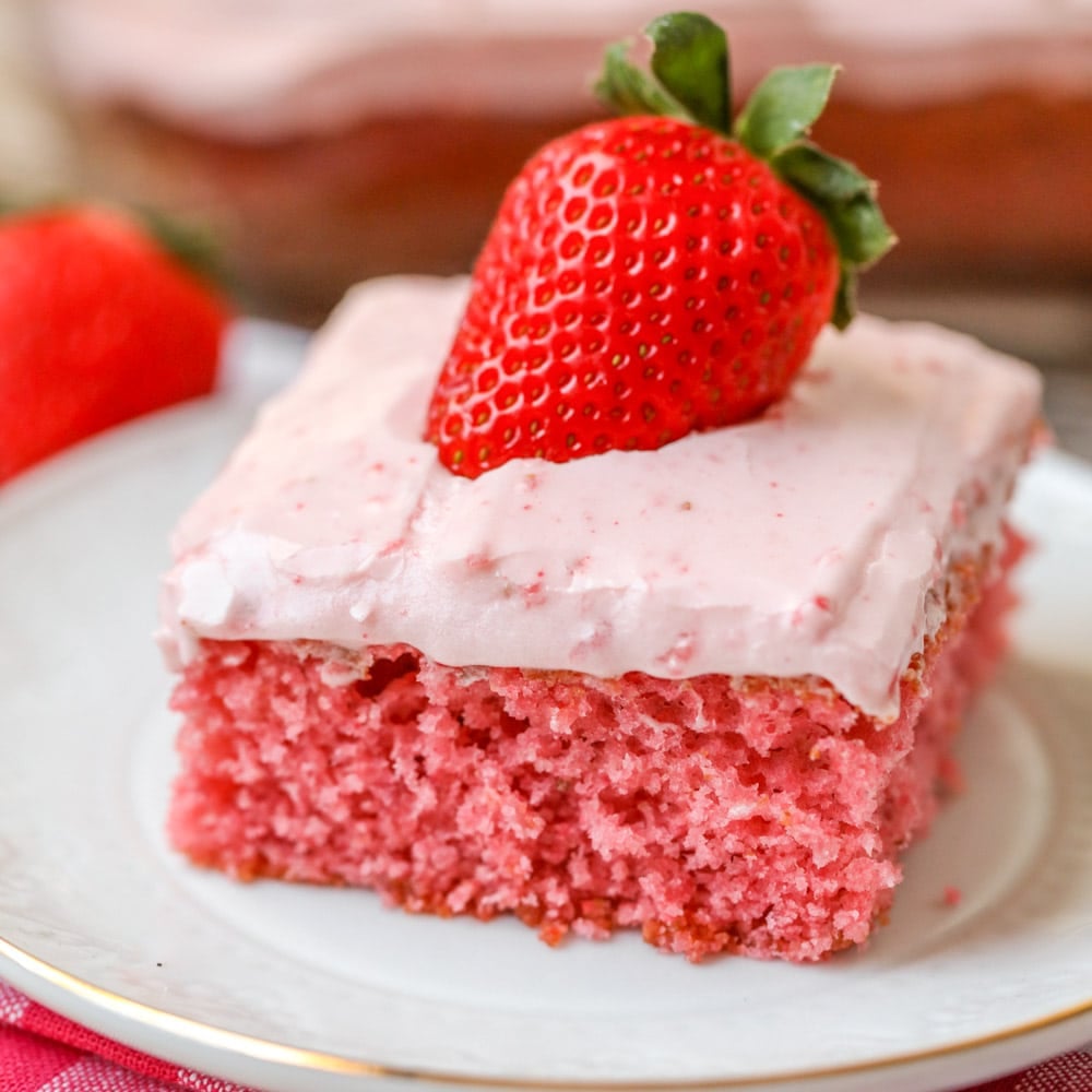 Strawberry sheet cake recipe served on white plate.