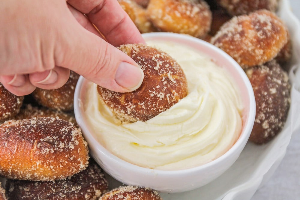 Dipping cinnamon pretzel bite into cream cheese dip