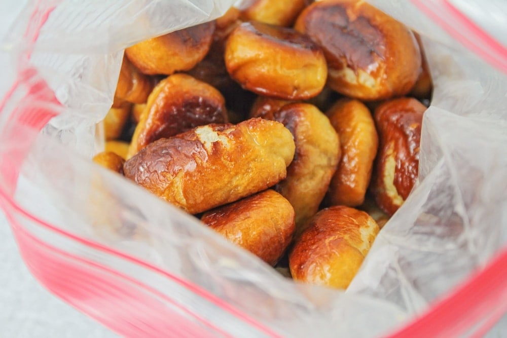 Cinnamon pretzel bites being coated in cinnamon sugar