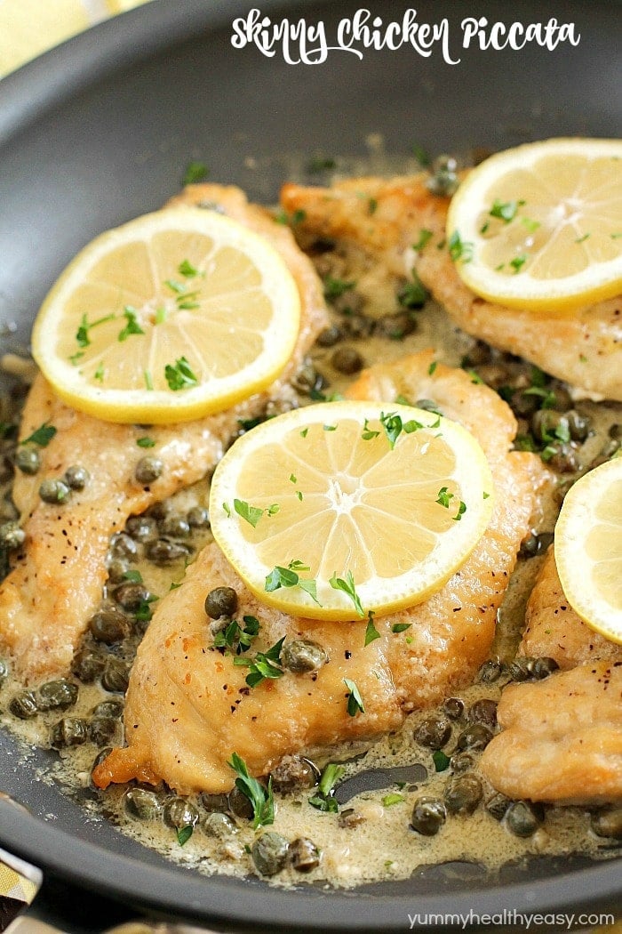 Healthy chicken piccata in a skillet with capers and lemon slices