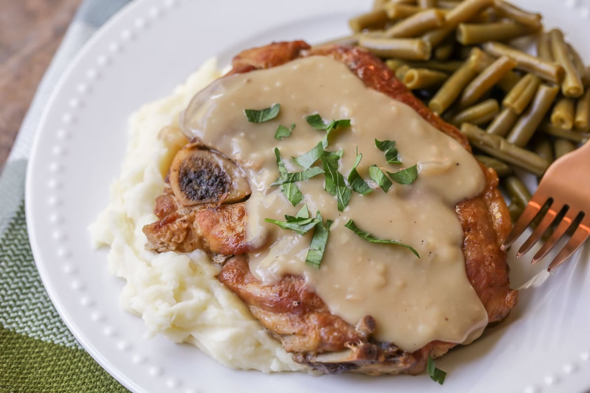 Family Dinner Ideas - Slow Cooker Pork Chops topped with gravy served over mashed potatoes.