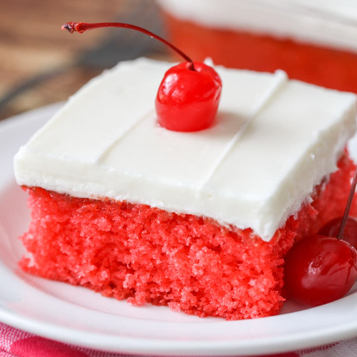 Easy Cake Recipes - A slice of Cherry Sheet Cake topped with a maraschino cherry. 